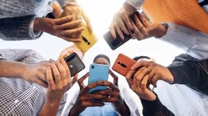 Im Kreise stehende Teenager mit Smartphone, Untersicht