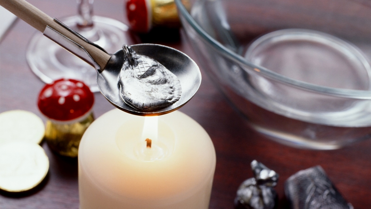 Schmelzen eines Bleiklümpchens über einer Kerzenflamme