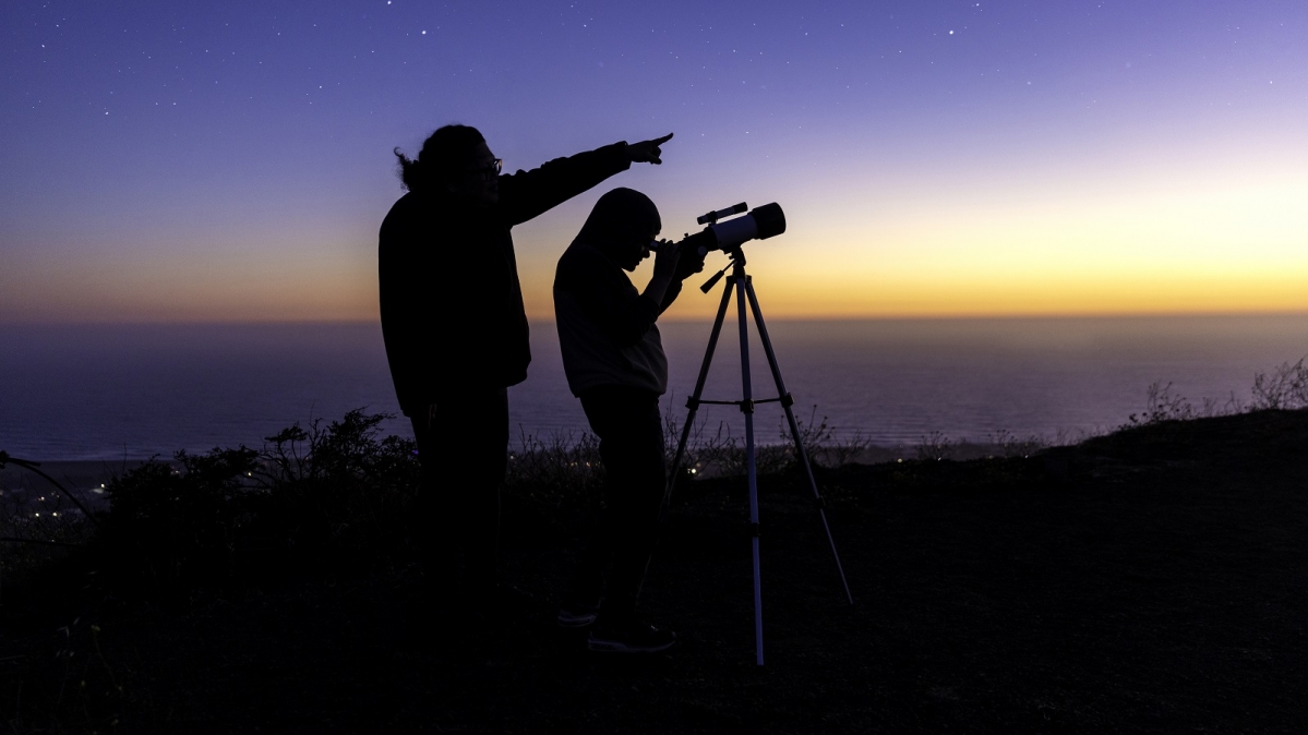 Zwei Personen mitr Teleskop bei der Himmelsbeobachtung