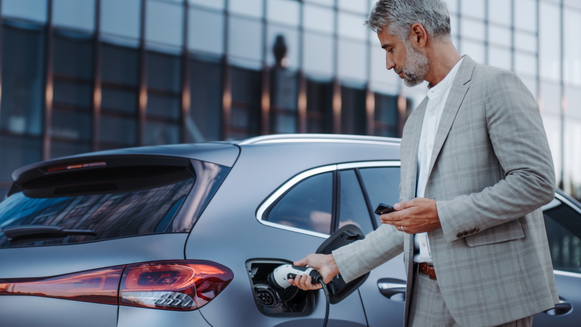 Autofahrer beim Anschließen eines Ladekabels