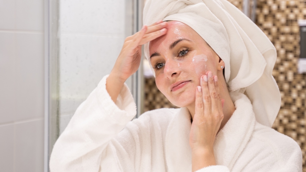 Frau bei der Gesichtspflege im Bad