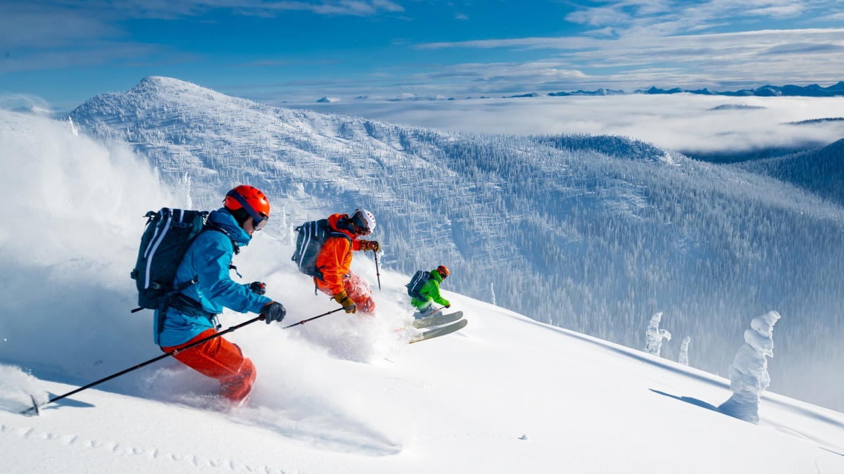 Drei Skiläufer bei der Abfahrt im Pulverschnee
