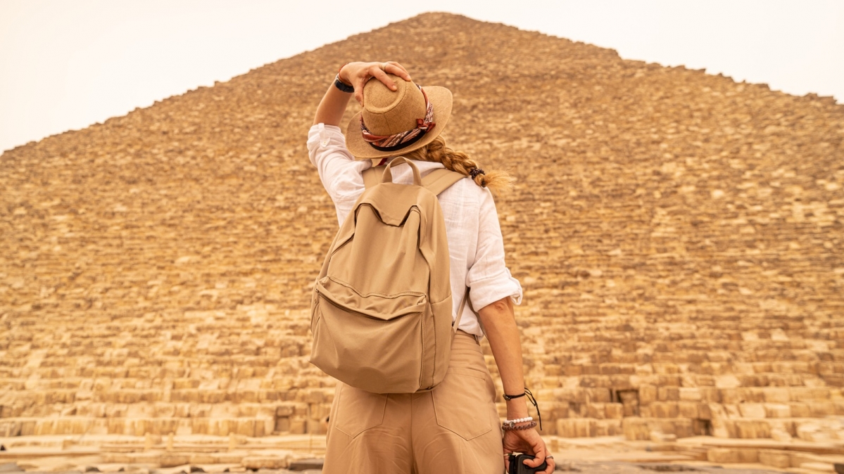Frau blickt zum Gipfel der Cheopspyramide emport