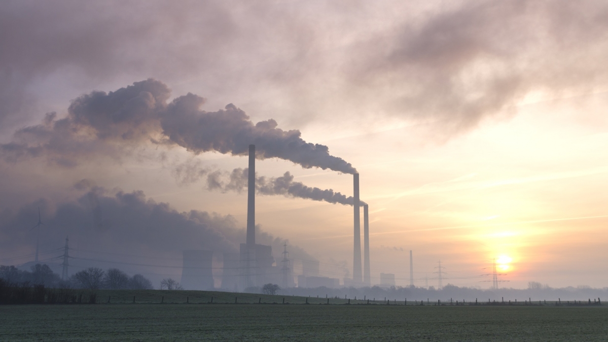 Rauchende Schornsteine bei Sonnenuntergang