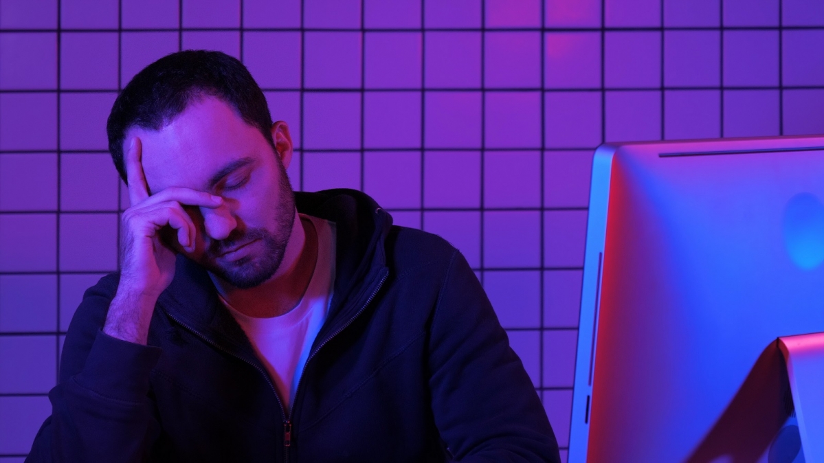 Übermüdeter Mann an Bildschirmarbeitsplatz