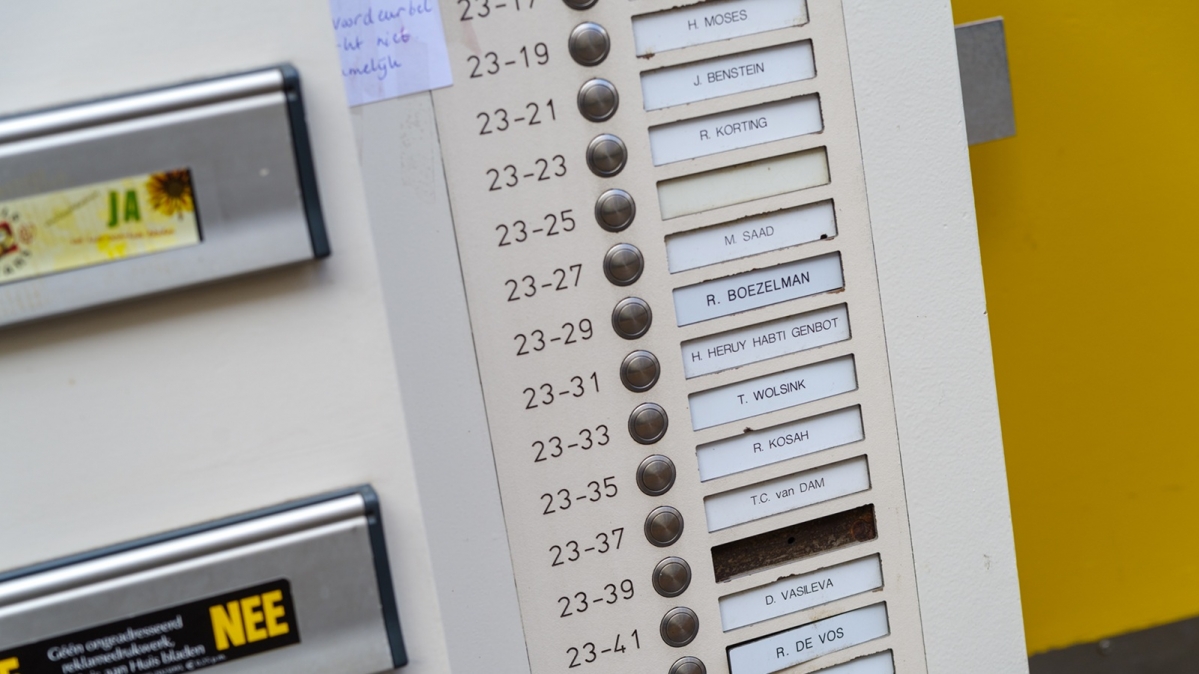 Klingelschilder und Briefkästen neben einer Haustür