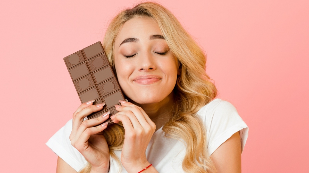 Junge Frau, die eine Schokoladentafel hochhält