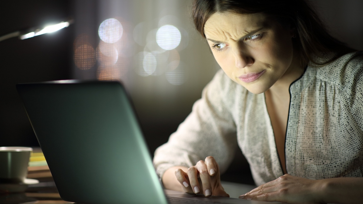 Frau mit irritiertem Gesichtsausdruck vor einem Laptop