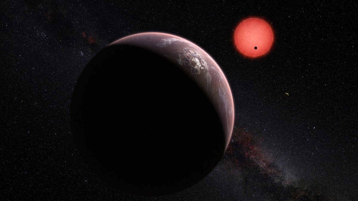 This artist’s impression shows an imagined view of the three planets orbiting an ultracool dwarf star TRAPPIST-1 just 40 light-years from Earth. These worlds have sizes and temperatures similar to those of Venus and Earth and may be the best targets found so far for the search for life outside the Solar System. They are the first planets ever discovered around such a tiny and dim star. In this view one of the inner planets is seen in transit across the disc of its tiny and dim parent star.