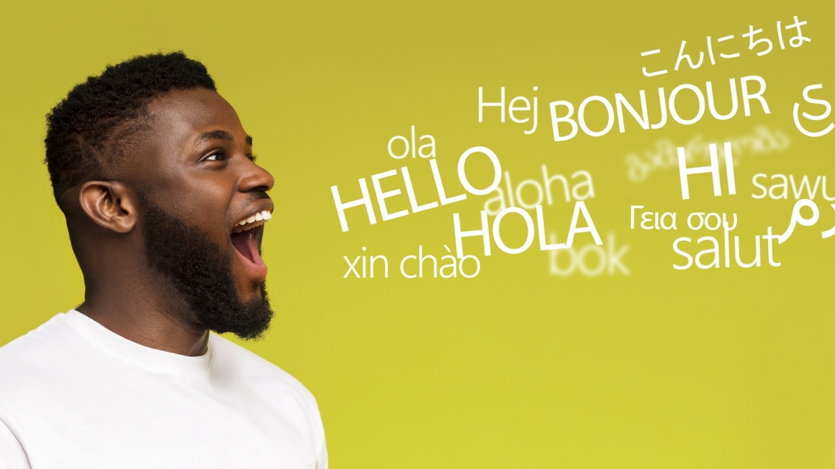 Junger Mann mit Begrüßungsworten in mehreren Sprachen