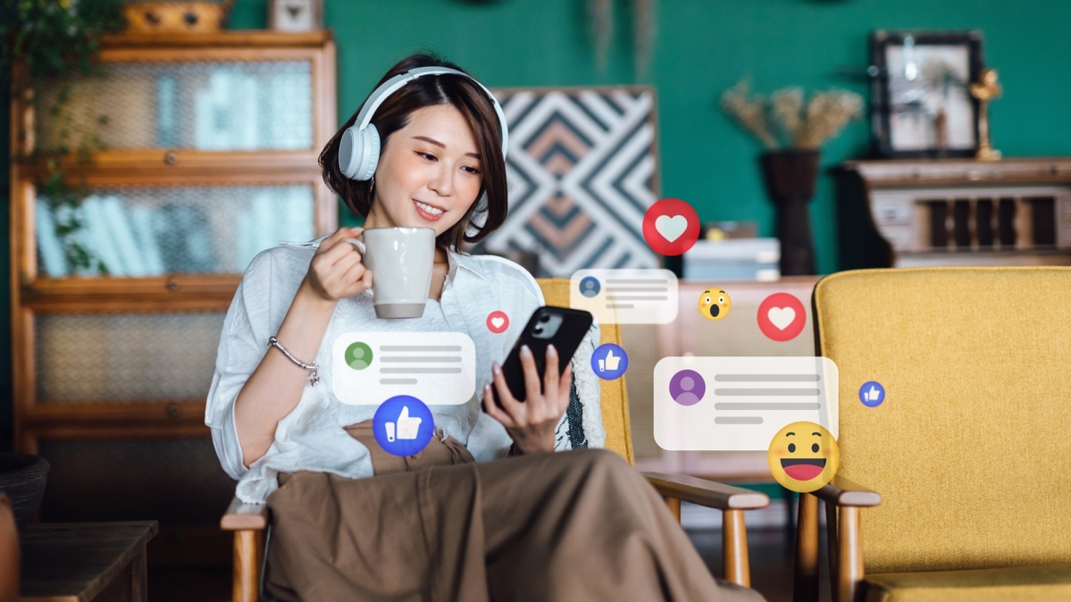 Junge asiatische Frau mit Kaffeebecher und Durchgehen ihrer Social-Media-Feeds