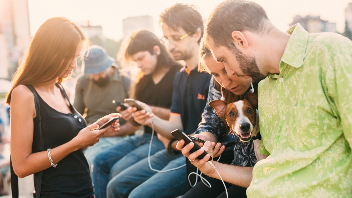 Gruppe junger Erwachsneer mit gezückten Smartphones