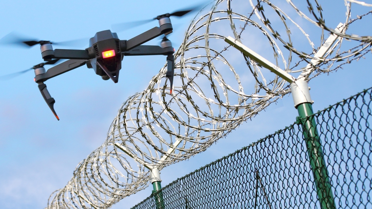 Drohne überfliegt stacheldrahtbewehrten Zaun