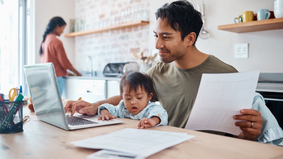 Homeoffice-Szene in Wohnküche mit Vater, Mutter und Kleinkind