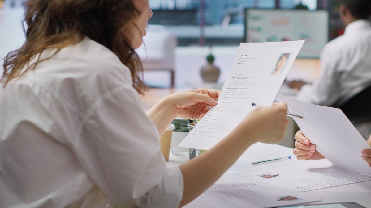 Personalvermittlerin bei Durchsicht von Bewerbungsunterlagen