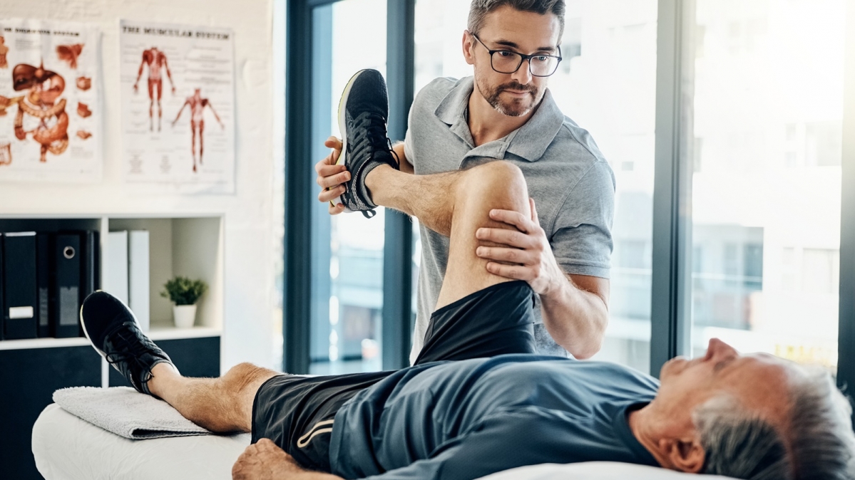 Physiotherapeut mit einem männlichen Patienten