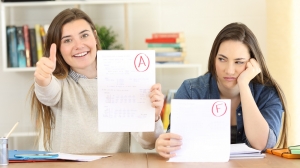 Zwei Schülerinnen mit sehr unterschiedlich  benoteten Klassenarbeiten