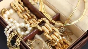Geöffnete Schmuckschatulle mit Goldschmuck und Perlenkette