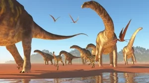 Herde Argentinosaurier an einem sandigen Seeufer