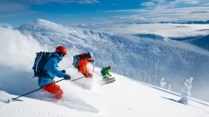 Drei Skiläufer bei der Abfahrt im Pulverschnee