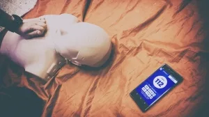 Erste-Hilfe-Reanimationspuppe und Smartphone mit Notrufmenü