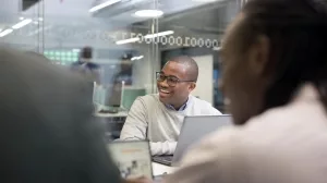 Besprechung, Mann mit Laptop an einem Tisch
