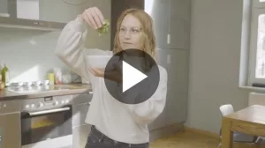 Junge Frau beim Würzen mit Koriander