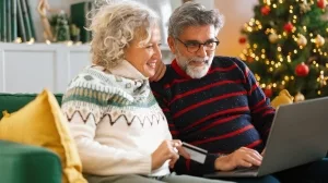 Seniorenpaar beim Online-Einkauf von Weihnachtsgeschenken.