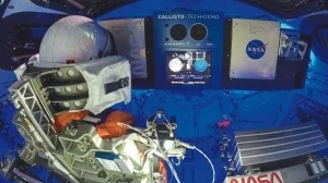 Blick ins Cockpit von Orion: Commander Moonikin Campos (links) – eine Messpuppe bestückt mit zahlreichen Sensoren – und das neue Kommunikationssystem Callisto (Mitte). ©NASA/Joel Kowsky