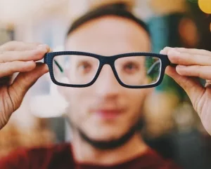 Junger Mann beim Anprobieren einer Brille