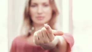 Frau zeigt Kontaktlinse auf ausgestreckte Zeigefinger vor