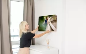 Junge Frau beim Aufhängen eines Fotodruck