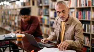 Älterer Mann bei Studium in einer Bibliothek