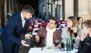 Kellner an einem vollbestzten Restaurantisch