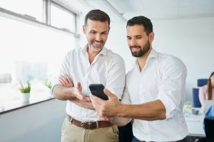 Zwie Männer unterhalten sich über einen Smartphone-Content