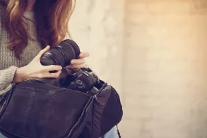 Frau beim Verstauen ihrer Kameraausrüstung