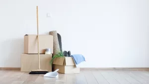 Leer geräumtes Zimmer mit drei Kartons, Besen ud Schaufel