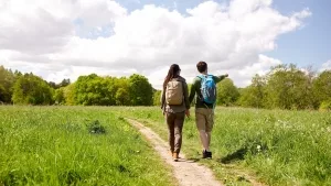 Paar beim Wandern in einer Wiesenlandschaft