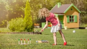 Mädchen bei einem Wurfspiel im Garten