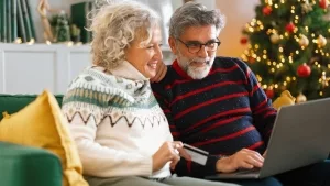 Seniorenpaar beim Online-Einkauf von Weihnachtsgeschenken.